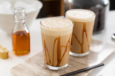 Två glas med karamellfrappe, redo att avnjutas. Ett enkelt frappe recept för en svalkande dryck.