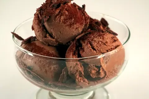 En skål med krämig chokladglass, toppad med chokladspån. Perfekt för ett enkelt chokladglass recept.