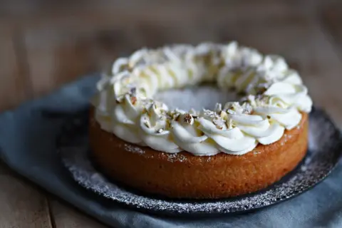 En kladdkaka med semla-inspirerad gräddkrans och hackade nötter. En dröm för alla fikasugna!