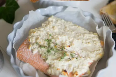 Lax med fetaost och crème fraiche, toppad med färsk timjan, serveras i en ugnsform. En härlig rätt för en mysig middag.