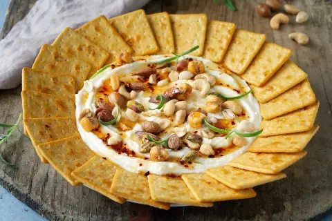 Krämig vispad fetaost med honung, nötter och chili, serverad med kex. En perfekt dipp för alla tillfällen.