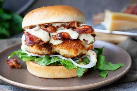 En saftig kycklingburgare med krispigt bacon och krämig dressing. Perfekt för ett hamburgerdressing recept.