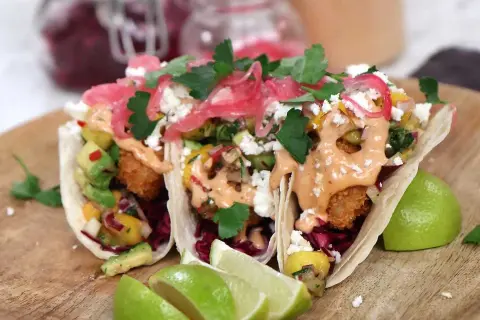 Tre läckra fish tacos med avokado, mango och en krämig sås. Perfekt för ett enkelt fish tacos recept.
