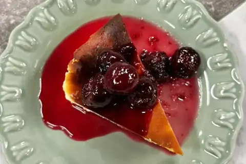 En bit krämig ostkaka med körsbärssås och hela körsbär. Perfekt för ett ostkaka recept.