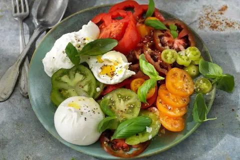 En krämig burrata med en blandning av färgglada tomater och färsk basilika. Ett enkelt och gott burrata recept.