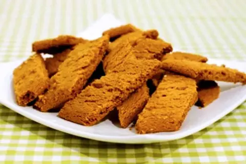 En hög med gyllene kolakakor på en vit tallrik, redo att avnjutas. Perfekt för ett enkelt kolakakor recept.