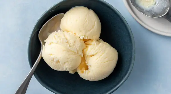 Tre skopor krämig vaniljglass i en mörkblå skål, redo att avnjutas. Perfekt för ett enkelt gelato recept.