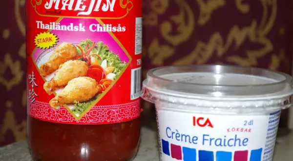 En flaska Mae Jin Thailändsk Chilisås och en burk ICA Crème Fraiche. Perfekt för en het och krämig smakupplevelse.