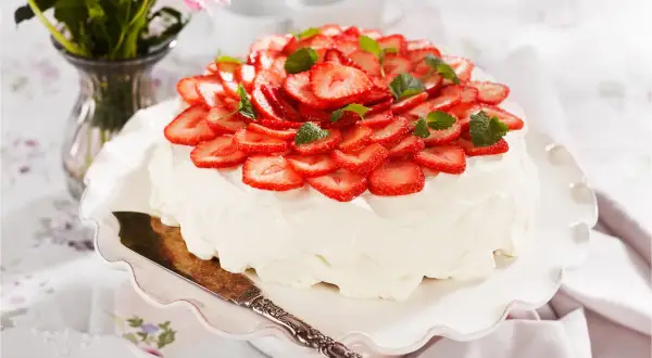 En vacker jordgubbstårta med fluffig grädde och färska jordgubbar. Tårtans fyllning är hemligheten bakom dess saftighet.