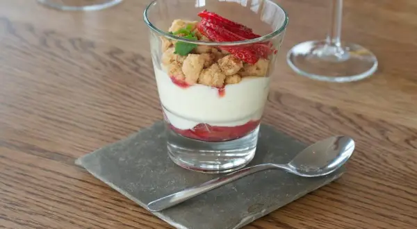En läcker rabarberdessert i glas med krämig vaniljkräm, smuldeg och färska jordgubbar. Perfekt för en somrig fika.