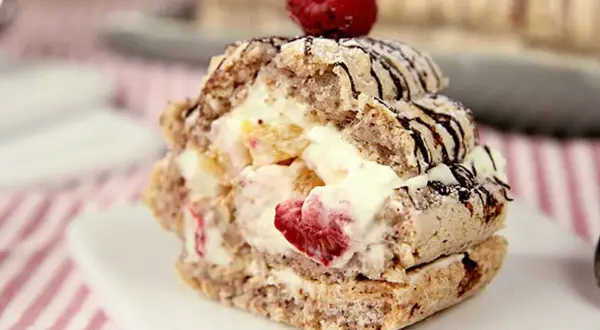 En läcker budapestbakelse med grädde och frukt, toppad med en hallon och chokladdrizzle.