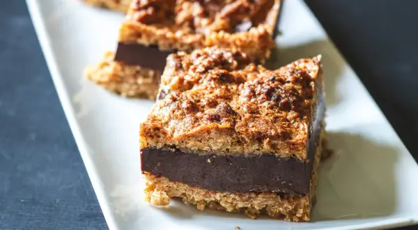 Tre sega havrerutor med chokladfyllning ligger på ett vitt fat.