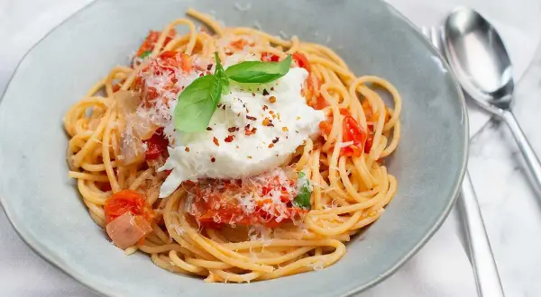 En krämig burrata pasta med tomatsås, toppad med färsk basilika och riven parmesan. Enkel men lyxig rätt.