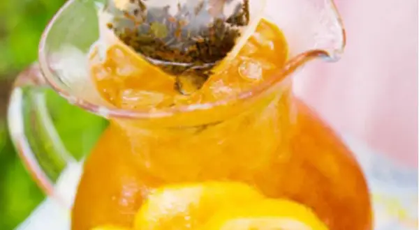 En karaff med iste, citronskivor och en tepåse som drar. Perfekt iste recept för en varm sommardag.
