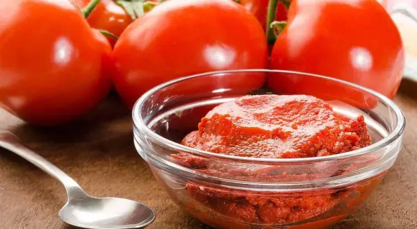 Färska tomater och en skål med tomatpuré, perfekt för ditt tomatpuré recept.