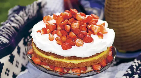En härlig jordgubbstårta med fluffig grädde och en syrlig lemoncurdfyllning, perfekt för sommaren.