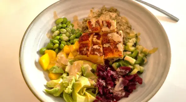 En färgglad bowl med lax, quinoa, edamamebönor, mango, avokado och rödbetor. Ett perfekt bowl recept för en hälsosam måltid.