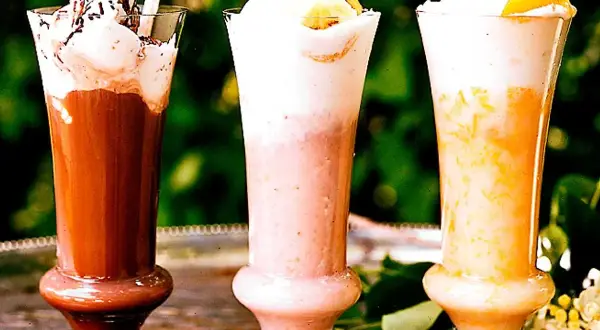 Tre läckra milkshakes i glas: choklad, jordgubb och aprikos. Perfekt för ett somrigt milkshake recept!