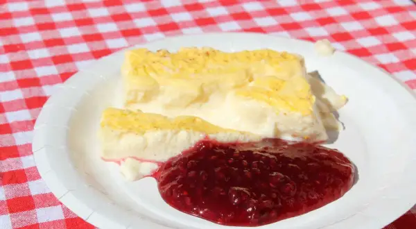 Två bitar krämig kalvdans med hallonsylt på en vit tallrik. Ett enkelt kalvdans recept för en härlig fika.