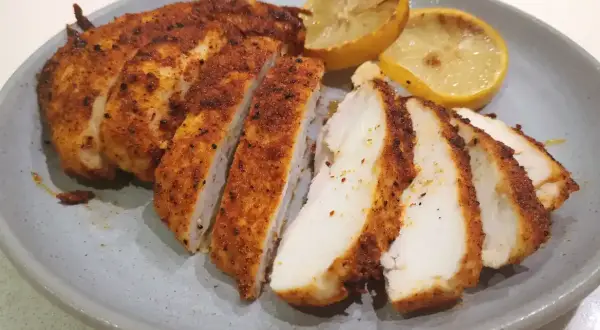Saftig kyckling i airfryer, skivad och serverad med grillade citronklyftor. Perfekt för en snabb och god middag.
