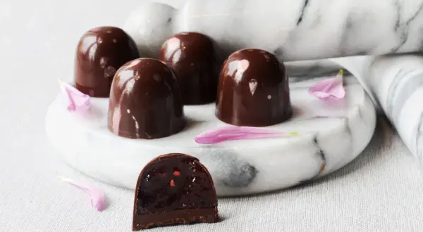 Chokladpraliner med glansigt skal, en skuren visar fyllning. Ett perfekt ganache recept till praliner.