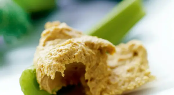 En klick krämig hummus på en krispig selleristjälk. Ett enkelt och gott recept på hummus som passar perfekt som mellanmål.