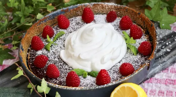 En härlig vegansk kladdkaka med fluffig grädde, färska hallon och myntablad. En perfekt dessert för alla tillfällen.