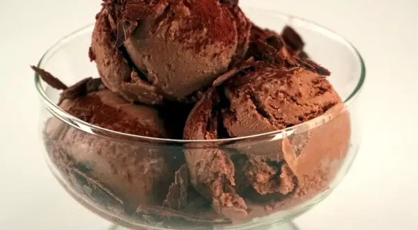 En skål med krämig chokladglass, toppad med chokladspån. Perfekt för ett enkelt chokladglass recept.