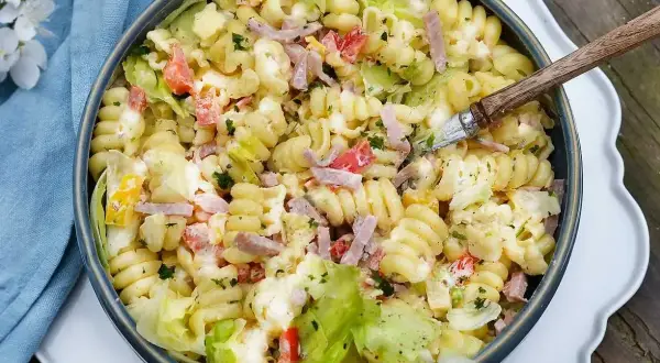 Krämig pastasallad med skinka, tomat och sallad. Perfekt dressing till pastasallad för en somrig buffé.