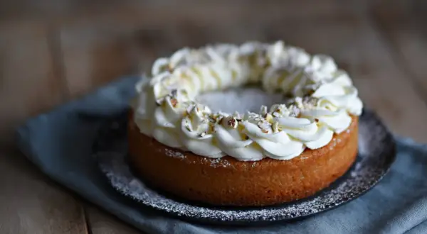 En kladdkaka med semla-inspirerad gräddkrans och hackade nötter. En dröm för alla fikasugna!