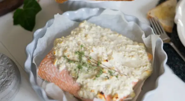 Lax med fetaost och crème fraiche, toppad med färsk timjan, serveras i en ugnsform. En härlig rätt för en mysig middag.