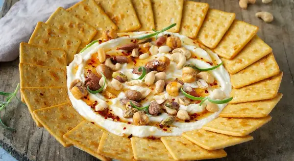 Krämig vispad fetaost med honung, nötter och chili, serverad med kex. En perfekt dipp för alla tillfällen.