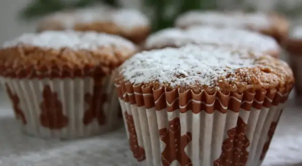 Pepparkaksmuffins recept: Nybakade muffins med pepparkakssmak, pudrade med florsocker och dekorerade med pepparkaksfigurer.