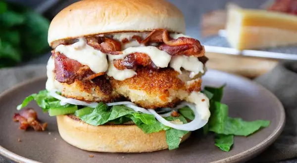 En saftig kycklingburgare med krispigt bacon och krämig dressing. Perfekt för ett hamburgerdressing recept.