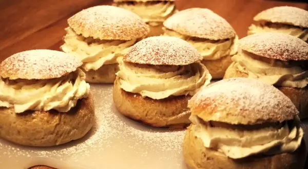 Flera gammaldags semlor med rikligt med grädde och pudrat florsocker. En klassisk svensk fika.