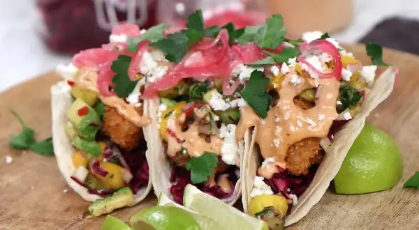 Tre läckra fish tacos med avokado, mango och en krämig sås. Perfekt för ett enkelt fish tacos recept.