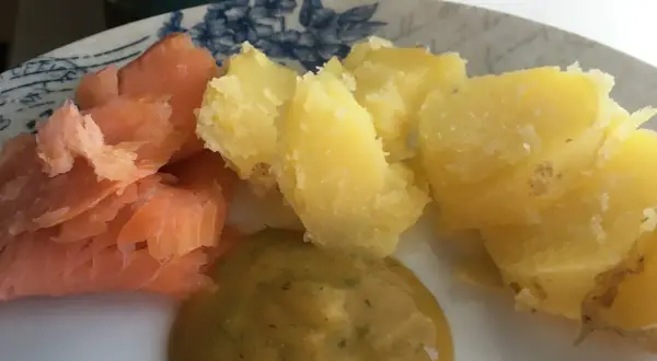 En tallrik med gravad lax, kokt potatis och en klick gravlaxsås. Perfekt för ett snabbt och gott recept.