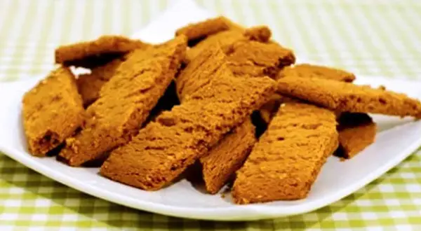 En hög med gyllene kolakakor på en vit tallrik, redo att avnjutas. Perfekt för ett enkelt kolakakor recept.