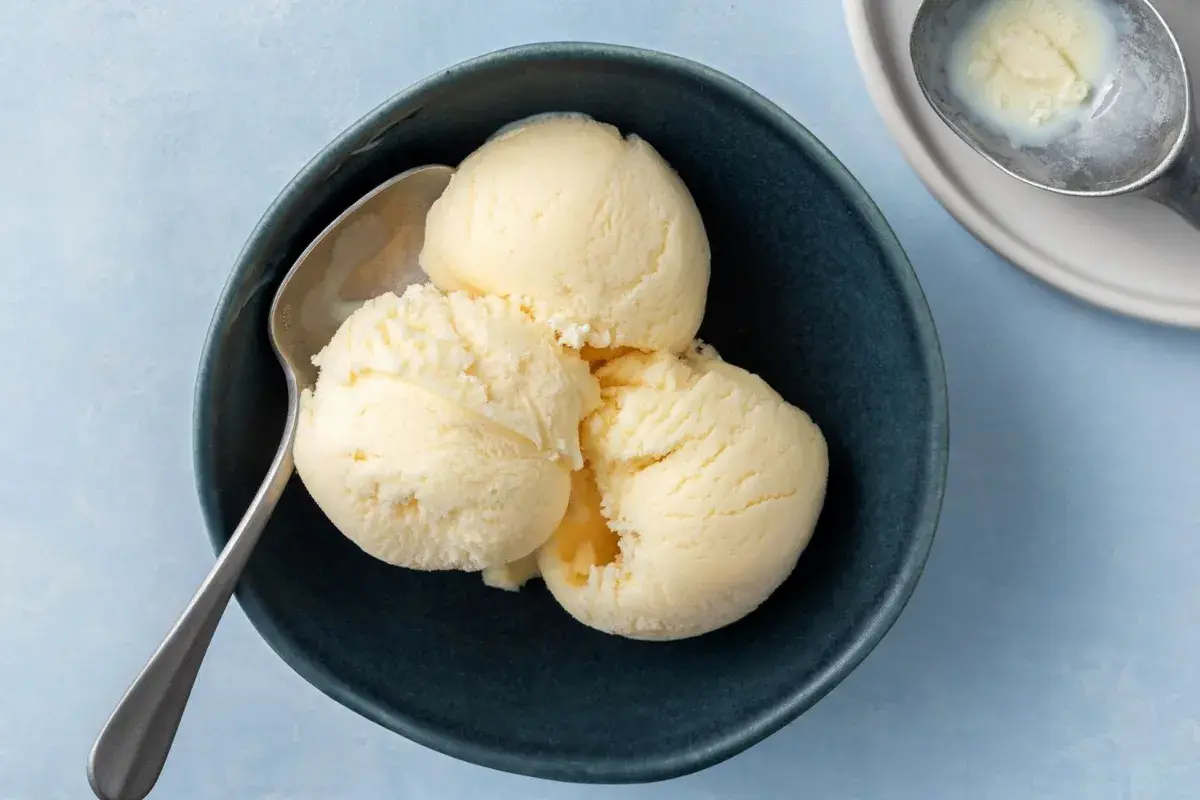 Tre skopor krämig vaniljglass i en mörkblå skål, redo att avnjutas. Perfekt för ett enkelt gelato recept.