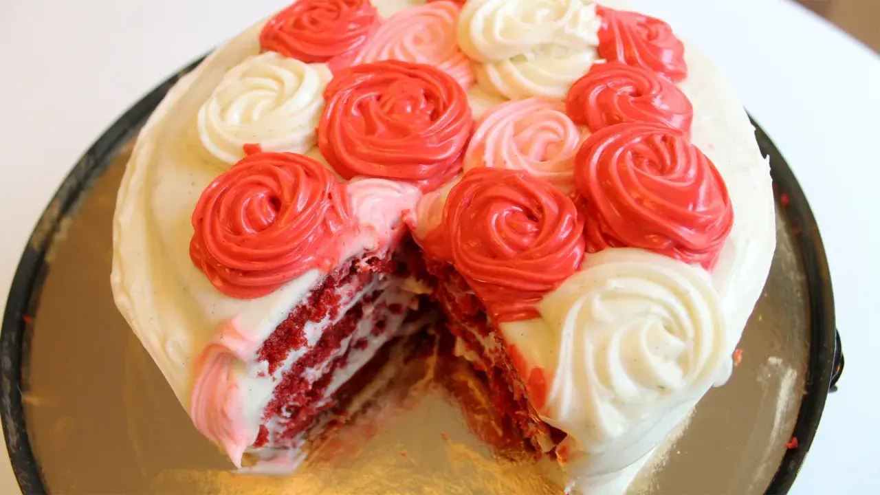 En skivad red velvet cake med fluffig frosting i rosformar.