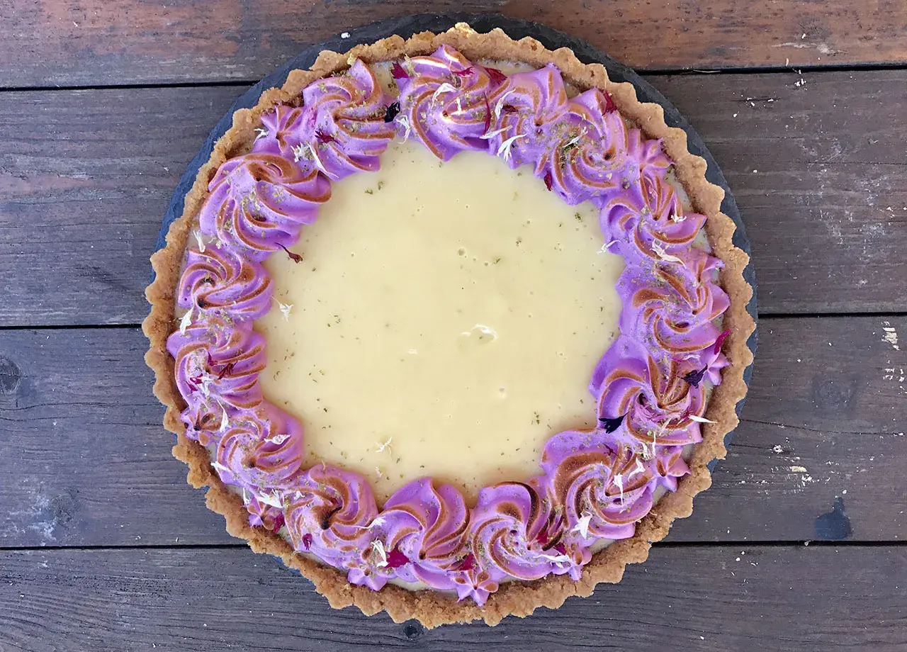 En vacker key lime pie med lila marängkant, perfekt för ett somrigt recept.