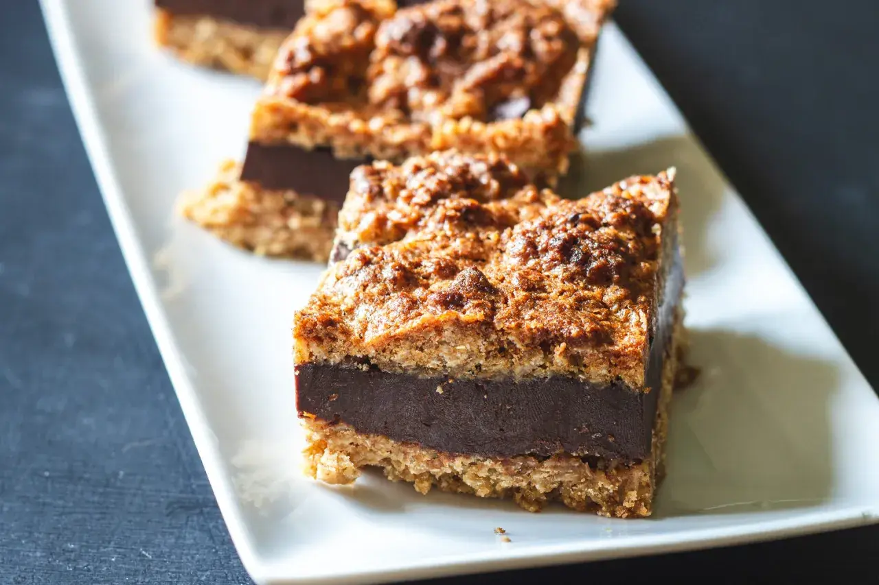 Tre sega havrerutor med chokladfyllning ligger på ett vitt fat.