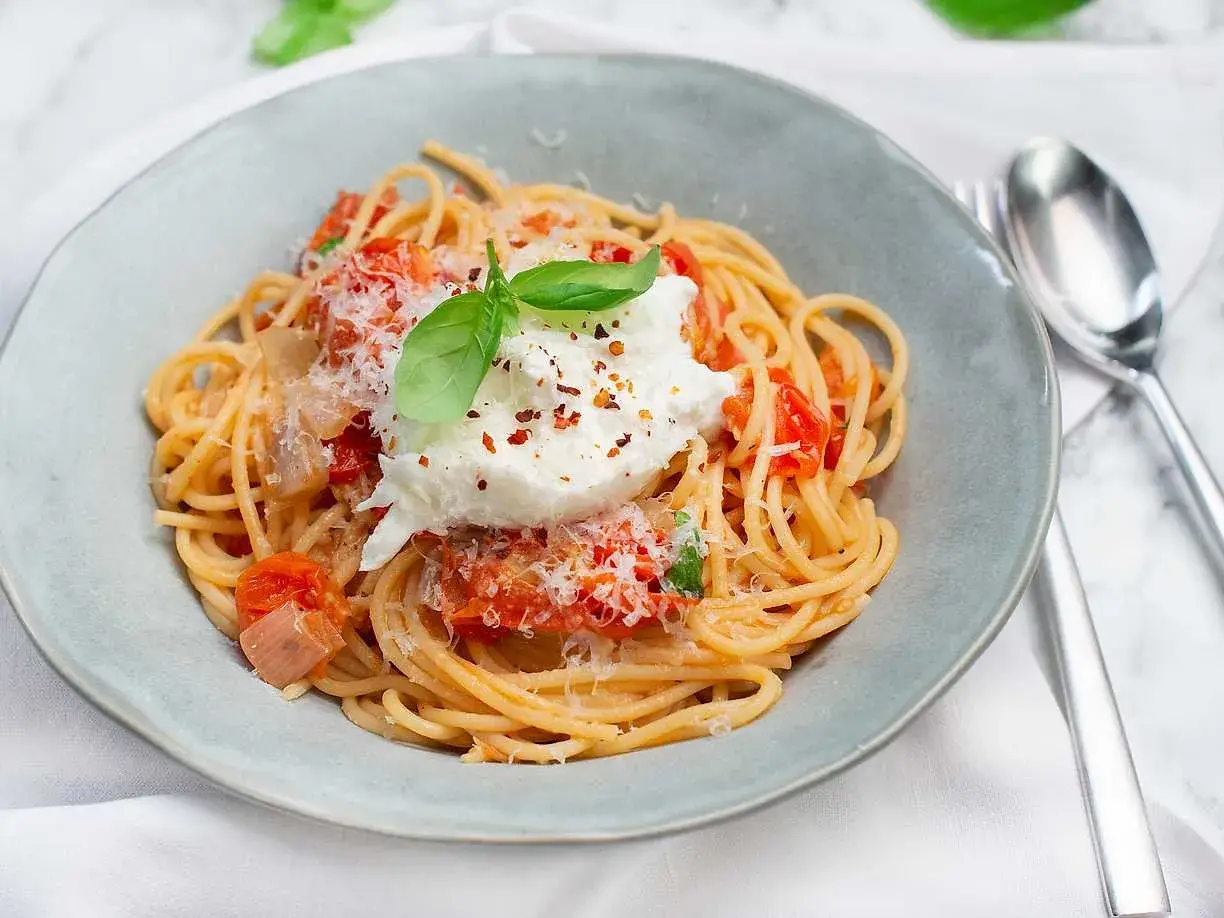 En krämig burrata pasta med tomatsås, toppad med färsk basilika och riven parmesan. Enkel men lyxig rätt.