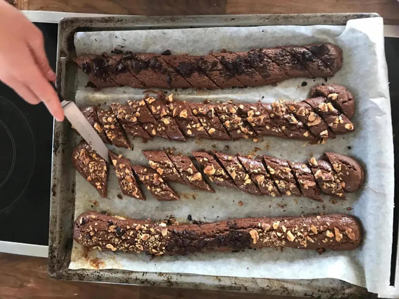 Chokladsnittar recept: Nybakade chokladkakor med nötter skärs upp på en plåt.