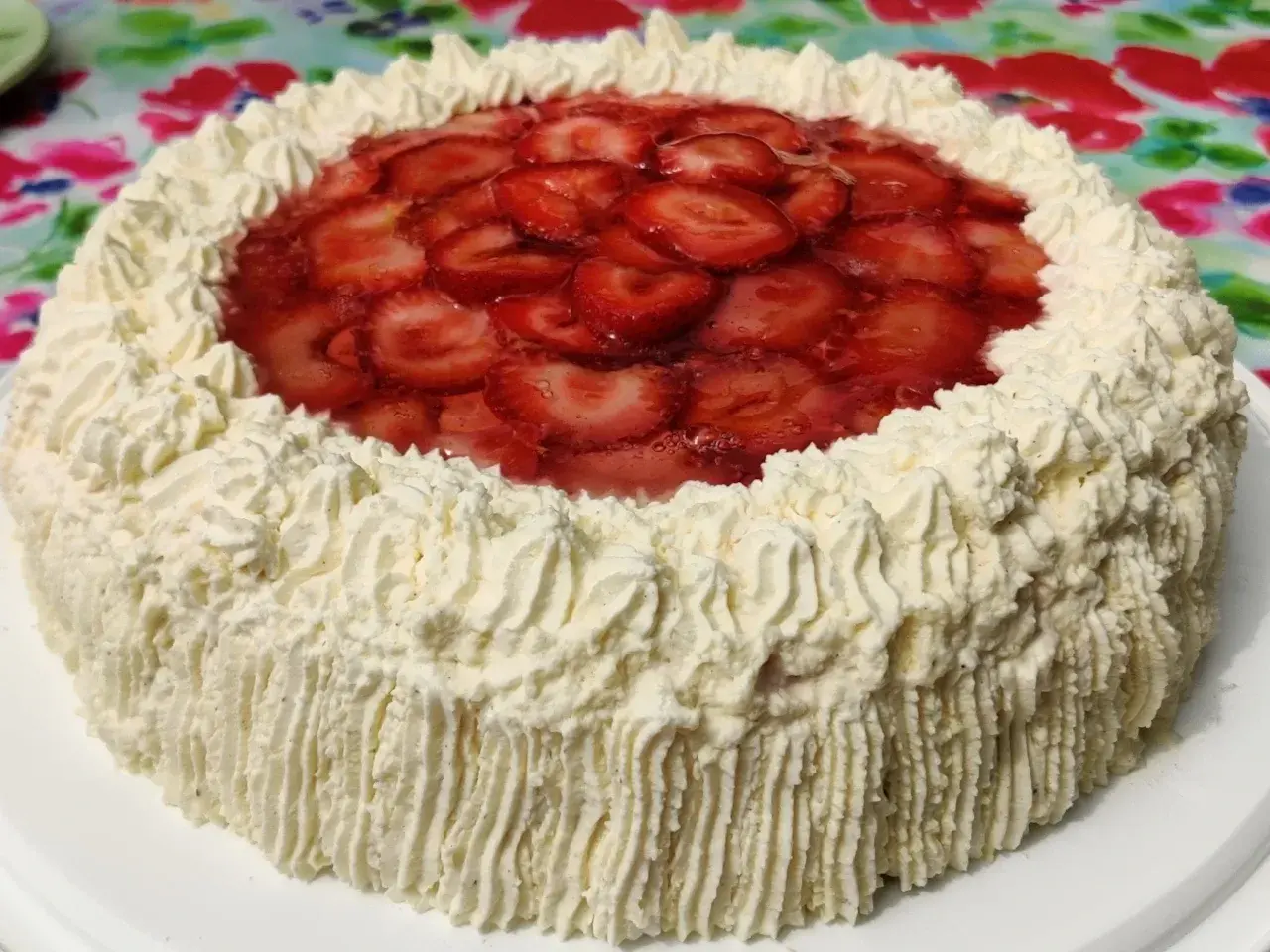 En himmelsk jordgubbstårta med fluffig grädde och glaserade jordgubbar på toppen. Perfekt för sommaren!