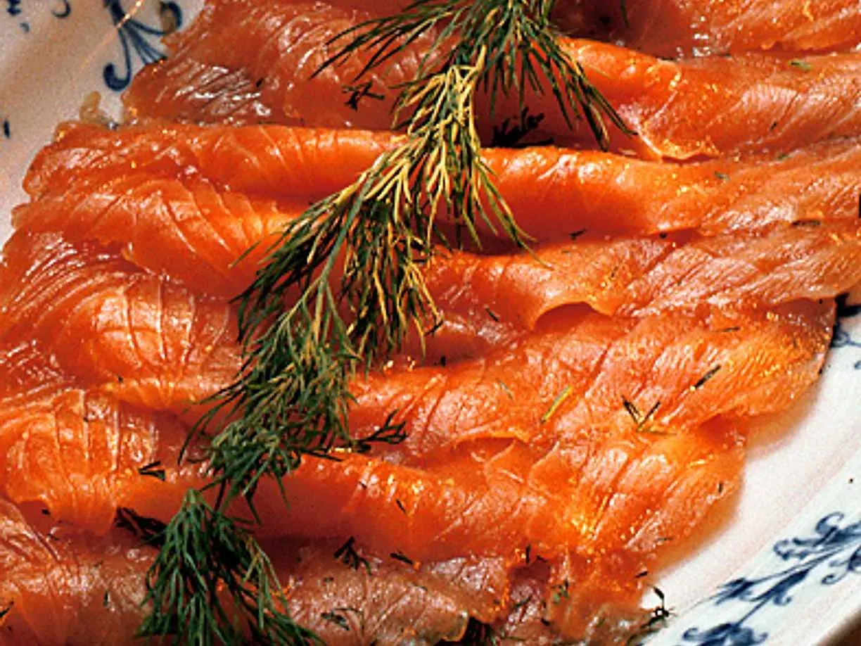Tunna skivor av rimmad lax med dill, redo att avnjutas.