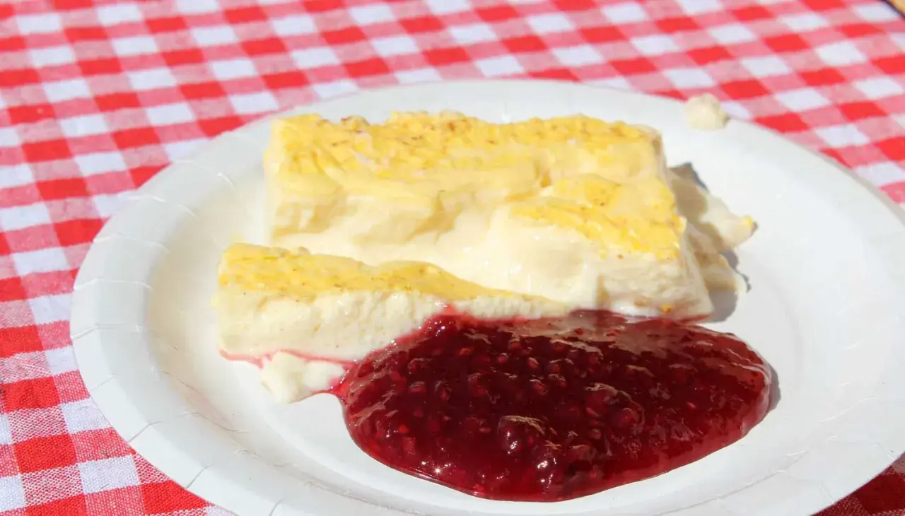 Två bitar krämig kalvdans med hallonsylt på en vit tallrik. Ett enkelt kalvdans recept för en härlig fika.