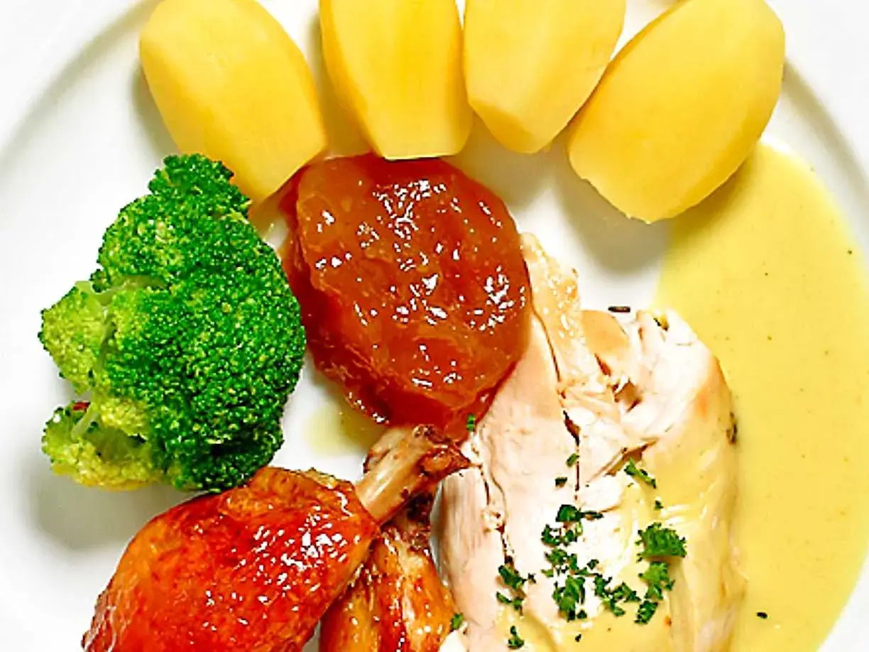 En tallrik med kyckling, potatis, broccoli och en härlig citronsås till kyckling.