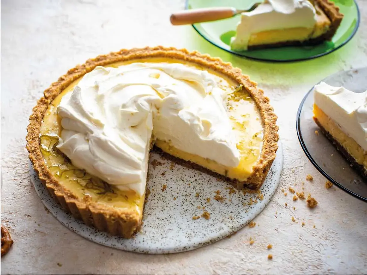 En krämig key lime pie med fluffig grädde, en bit serverad på en grön tallrik.