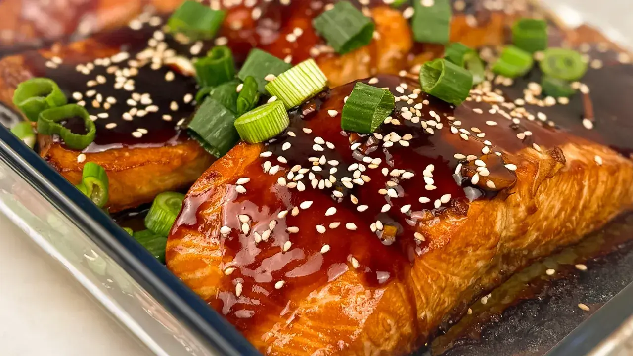 Saftig teriyaki lax med sesamfrön och färsk grön lök, redo att avnjutas.